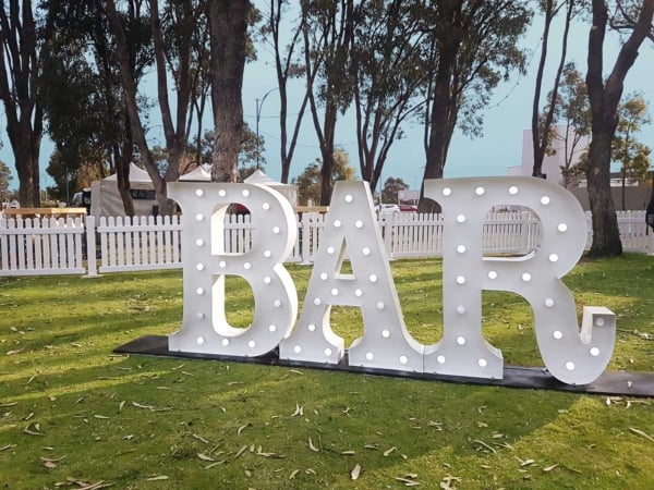 Bar light up letters in on a lawn.