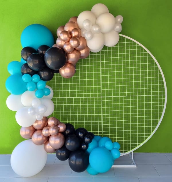 Turquoise, gold and black balloons arranged on a circular white mesh.