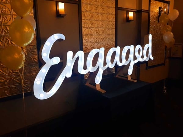 Giant light up LED Engaged letters at an indoor engagement party.
