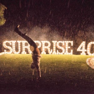 Giant light up letters on a lawn at night in the rain.