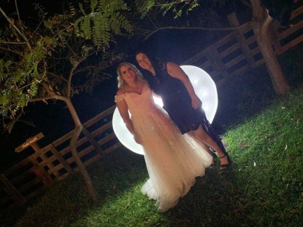 Giant LED light up heart with bride and bridesmaid at night.