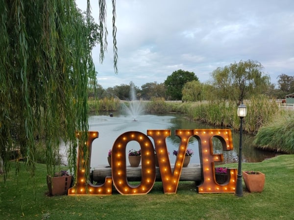 Giant light up love letters under a willow tree at Brookleigh Estate in Perth's Swan Valley.