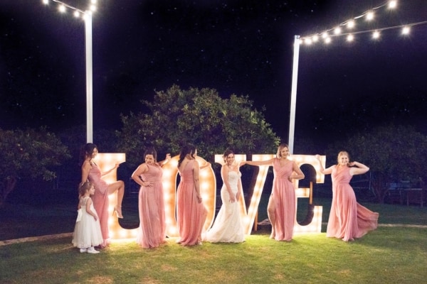 Bridal party in front of golden LED light up Love letters at Core Cider House.
