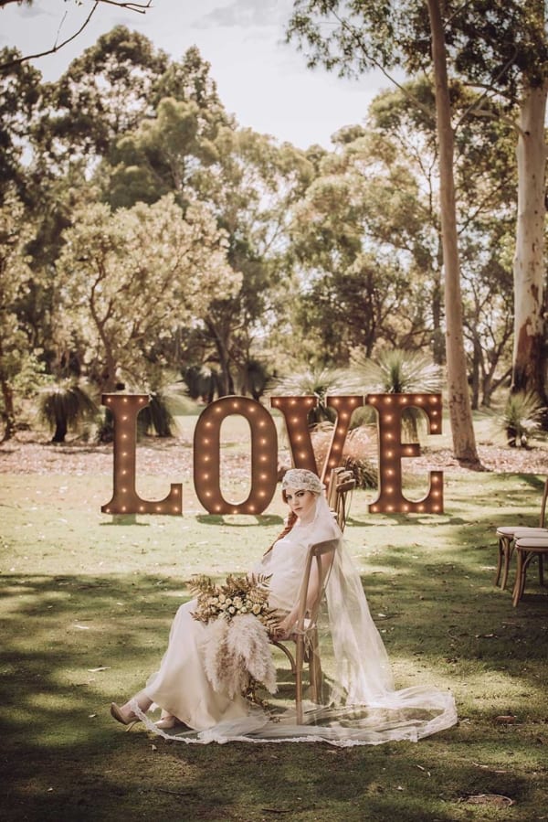Giant light up love letters at an outdoor wedding.