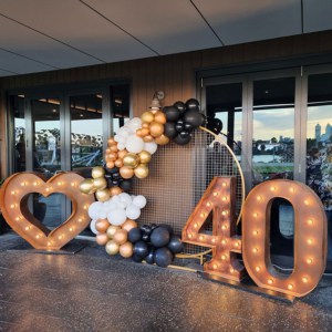 Giant number lights, a LED light up heart and a garland of black and gold balloons for a 40th birthday party.