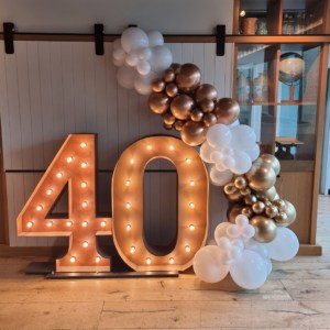Giant 40 number lights with gold & white balloons for a birthday celebration.