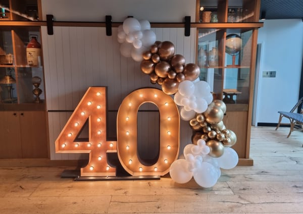 Giant 40 number lights with gold & white balloons for a birthday celebration.