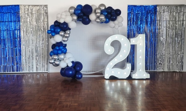 Giant 21 number lights with silver and blue balloons.