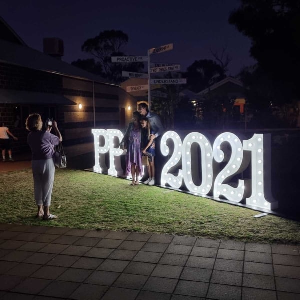 Family posing in front of giant light up numbers.