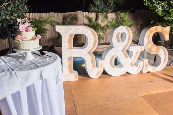 Giant light up bride and groom initials at a wedding.