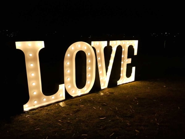Big light up love letters for an outdoors wedding at night.