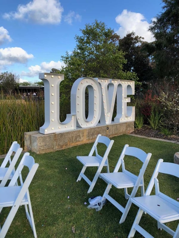Giant love letters at an outdoors daytime wedding.