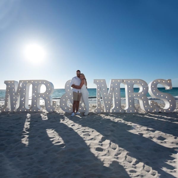 Giant light up MR & MRS letters at a beach wedding.