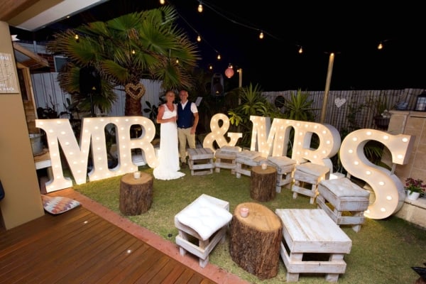 Giant MR & MRS light up letters in the backyard at a small wedding.