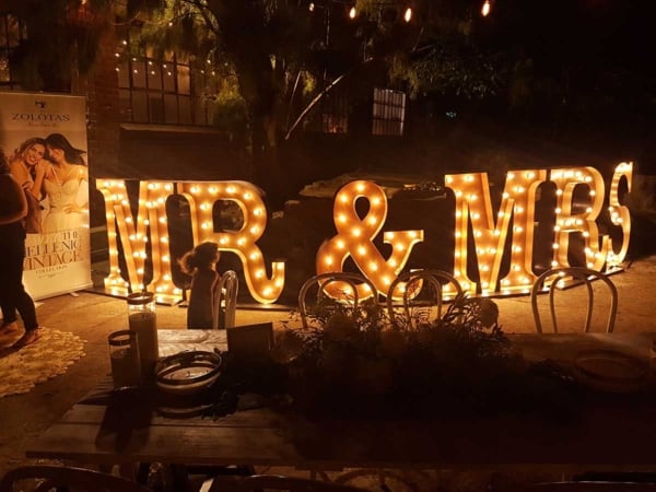 A night time event illuminated by rustic gold light up MR & MRS letters.