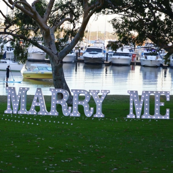 MARRY ME light up letters at a marina.